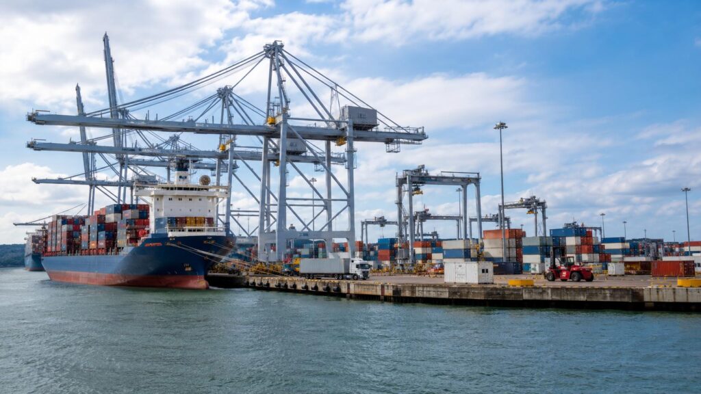 UK port cargo terminal with container cranes and cargo ships for imports from China